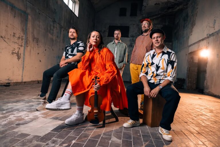 Bandbild på TLEQ fotat i en gammal industrilokal. En håller i en fiol, en sitter på en trumma.